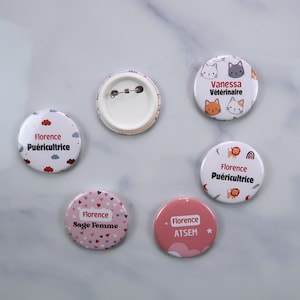 Peut inclure: Cinq badges bouton différents avec des designs et des textes variés. Les badges sont ronds et ont un fond blanc. Le texte sur les badges comprend "Florence Puericultrice", "Florence Sage Femme", "Florence ATSEM", "Vanessa Veterinaire" et "Florence Puericultrice".