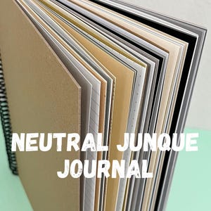May include: A neutral colored journal with a variety of paper colors and textures. The cover is a brown cardboard with the text "NEUTRAL JUNQUE JOURNAL" printed in white.
