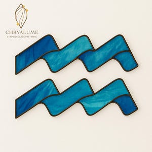 Könnte beinhalten: Glasmalerei-Zeichen für das Sternzeichen Wassermann in Blau mit schwarzen Konturen. Das Bild zeigt den Text "CHRYALUME STAINED GLASS PATTERNS" und ein goldenes Blattdesign.