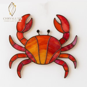 May include: A stained glass crab in red, orange, and yellow hues, outlined in dark brown. The crab features two prominent claws and multiple legs. The text "CHRYALUME STAINED GLASS PATTERNS" is displayed in the upper left corner.