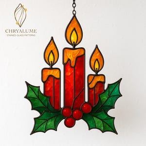 Puede incluir: Decoración navideña de vidrieras con tres velas rojas con llamas naranjas, sobre hojas verdes de acebo y bayas rojas. La pieza está suspendida por una cadena y presenta el texto "CHRYALUME STAINED GLASS PATTERNS".