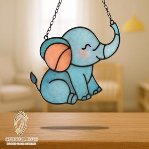 May include: A stained glass elephant in shades of blue and orange, with a black outline and a chain for hanging. The elephant has a smiling face and is suspended in the air. The logo "CHRYALUME STAINED GLASS PATTERNS" is at the bottom.