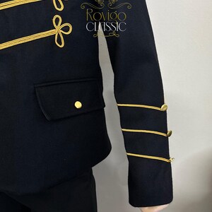 May include: A navy blue jacket with gold detailing. The jacket has gold trim and buttons, with embroidered accents on the chest and sleeves. A small pocket and gold button are visible. The text "Rovigo Classic" is on the jacket.