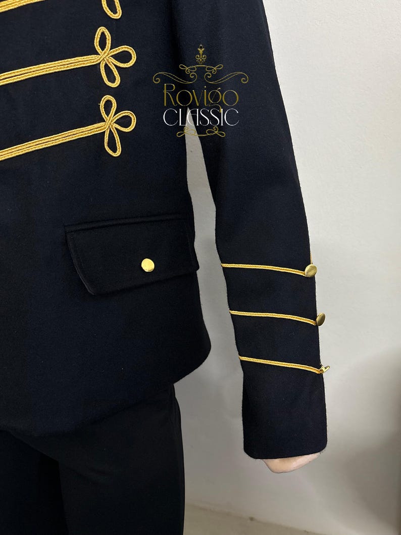 May include: A navy blue jacket with gold detailing. The jacket has gold trim and buttons, with embroidered accents on the chest and sleeves. A small pocket and gold button are visible. The text "Rovigo Classic" is on the jacket.