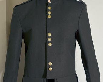 Könnte beinhalten: Eine dunkelgraue Jacke mit einem Mandarinkragen und goldenen Knöpfen. Die Jacke hat ein einzigartiges Design mit einem abgerundeten Saum und Taschen.