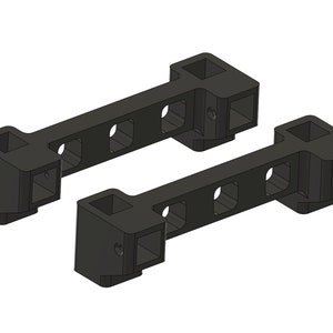 以下が含まれることがあります： 4つの正方形の穴がそれぞれ開いた黒い金属製のブラケットが2つ。ブラケットは壁や他の表面に取り付けるように設計されています。