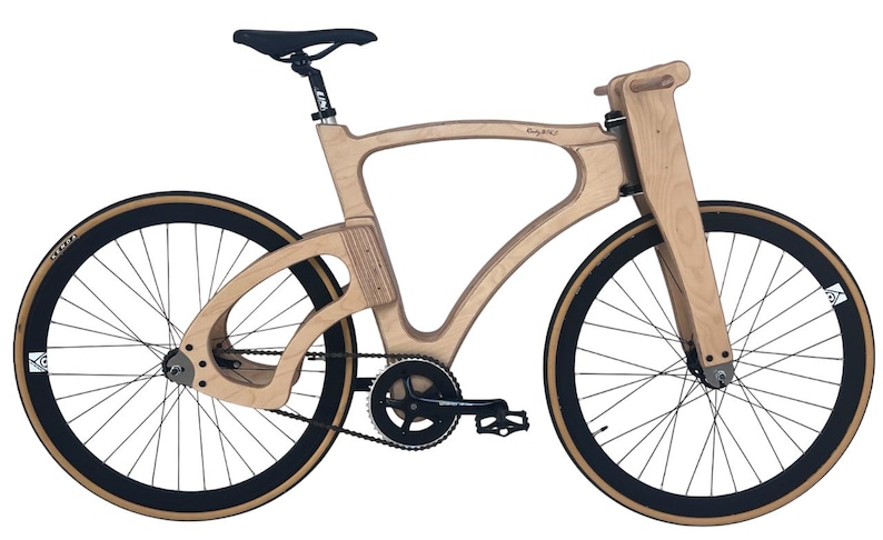 May include: A unique wooden bicycle with a light brown frame and black tires. The bike features a sleek, modern design with a black seat and a chain-driven drivetrain. The wheels have a diameter of approximately 28 inches.
