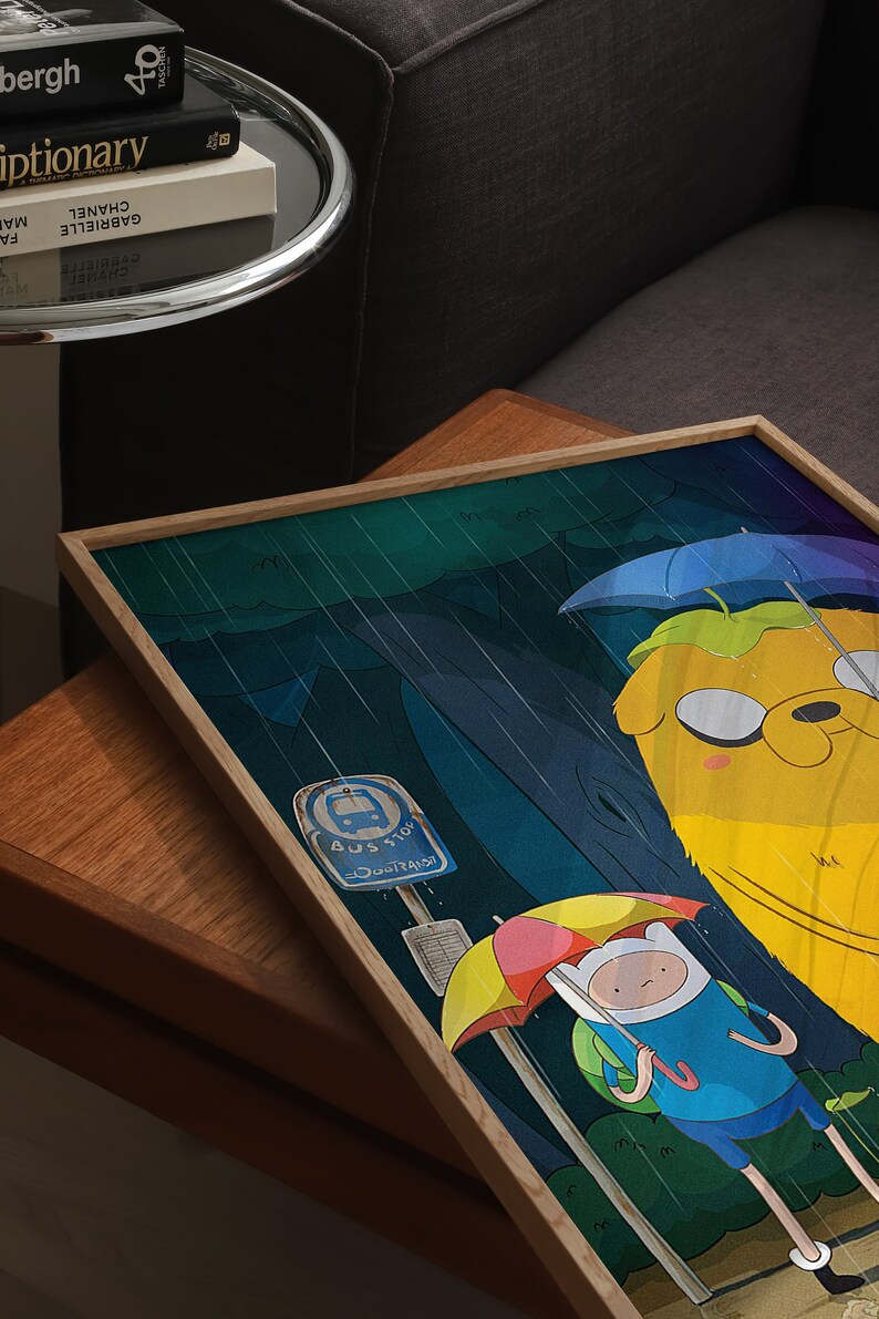 K&ouml;nnte beinhalten: Eine gerahmte Illustration von zwei Zeichentrickfiguren, Finn und Jake, aus der Zeichentrickserie Adventure Time. Finn h&auml;lt einen gelben und roten Regenschirm und Jake h&auml;lt einen blauen Regenschirm. Der Hintergrund ist ein dunkelblauer und gr&uuml;ner Wald mit fallendem Regen. Der Text "BUS STOP" ist auf einem Schild sichtbar.