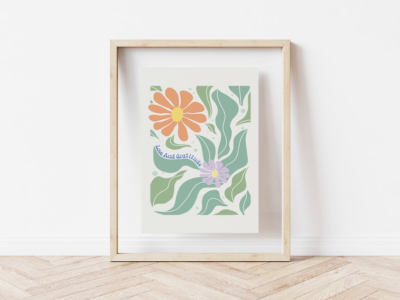 May include: A framed print with a floral design featuring orange and purple flowers with green leaves. The text "Love And Gratitude" is written in blue on a white background.