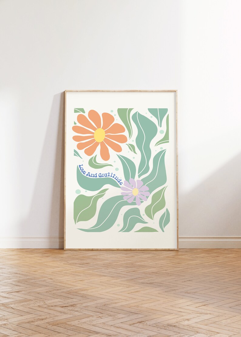 May include: A framed print with a floral design featuring orange and purple flowers with green leaves. The text "Love and Gratitude" is written in blue on the print.