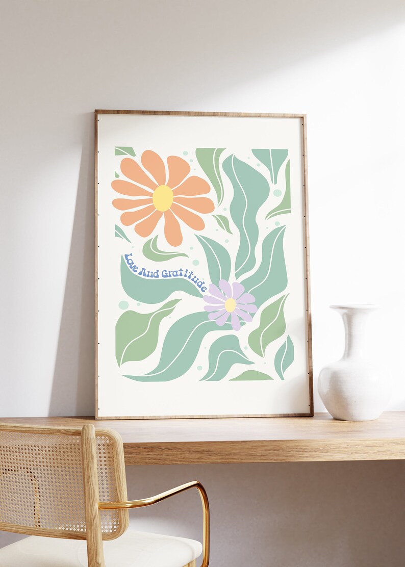 May include: A framed print with a floral design featuring orange, green, and purple flowers. The text "Love And Gratitude" is written in blue on the print.
