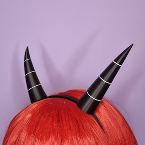 Helluva boss Millie character imp horns for cosplay or halloween, they are black and white with red background and they have a hairband to hold them