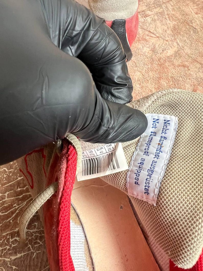 May include: Close-up of a beige and red sneaker interior. A white tag with black text reads "Nicht Farmfest ausger&uuml;stet Not Farmproof equipped". The shoe size is US 7.5, EUR 40, and CM 25.5.