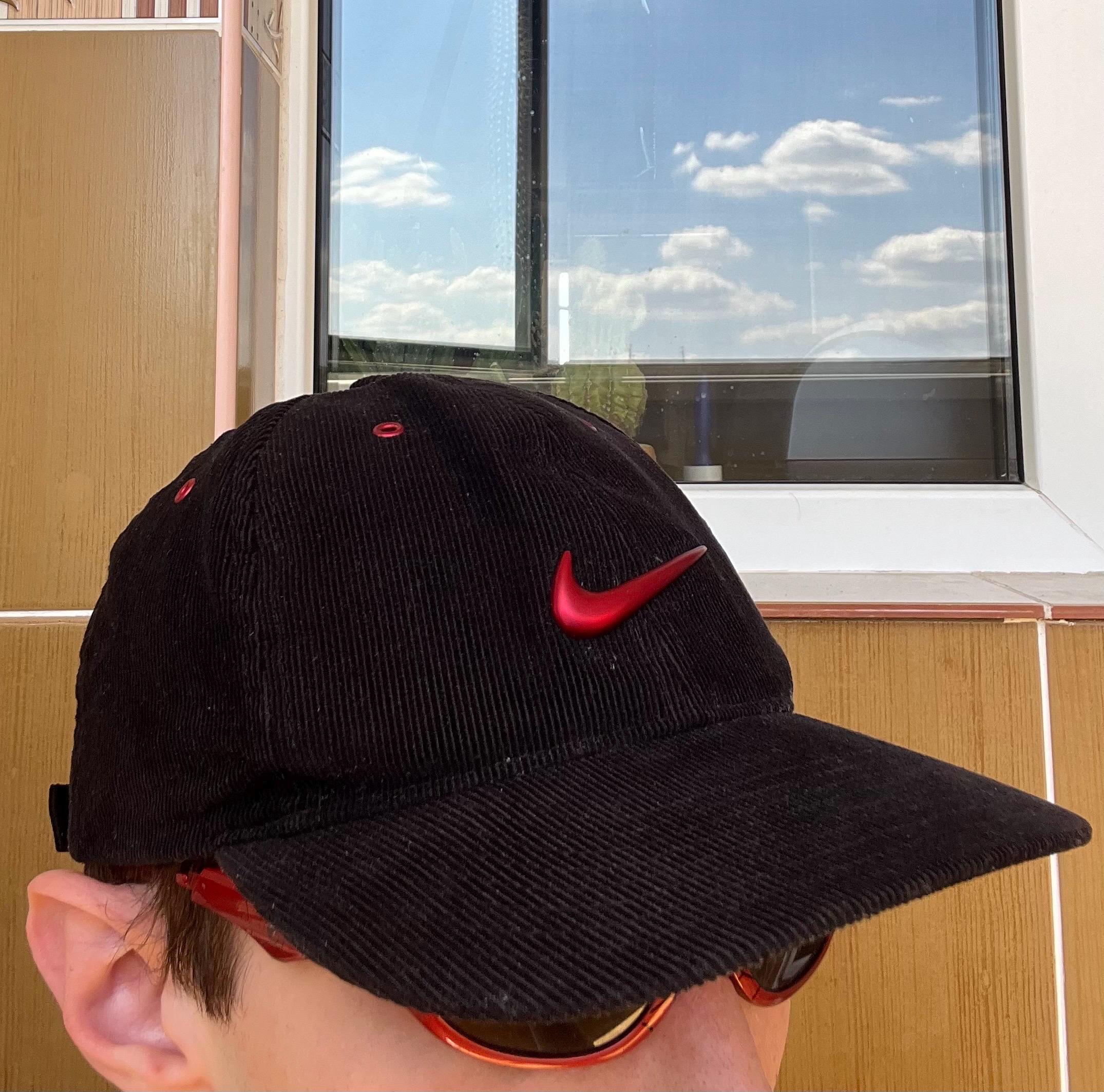 black nike hat with red swoosh