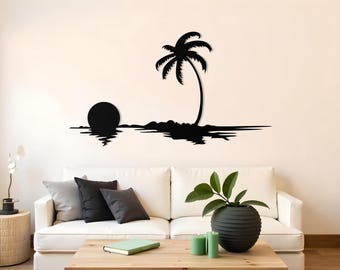May include: A black metal wall art piece depicting a tropical beach scene. The silhouette features a palm tree, a setting sun, and the ocean. The artwork is mounted on a cream-colored wall above a white sofa.