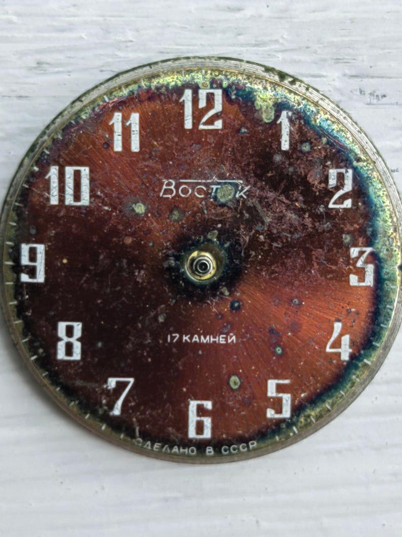 May include: Vintage watch face with a distressed, reddish-brown dial. White numerals mark the hours, with the brand name "Восток" and the text "17 камней" visible. The words "СДЕЛАНО В СССР" are also present.