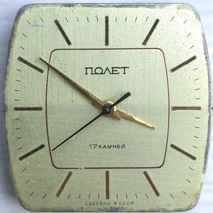 May include: A vintage gold-toned square clock with the word "ПОЛЕТ" in black. The clock face has black and gold hands and the text "17 KAMHEЙ" and "СДЕЛАНО В СССР". The clock has a brushed metal finish.