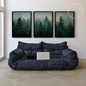 K&ouml;nnte beinhalten: Drei gerahmte Drucke eines nebeligen Waldes mit hohen immergr&uuml;nen B&auml;umen. Die Drucke h&auml;ngen an einer wei&szlig;en Wand &uuml;ber einem schwarzen Sofa.