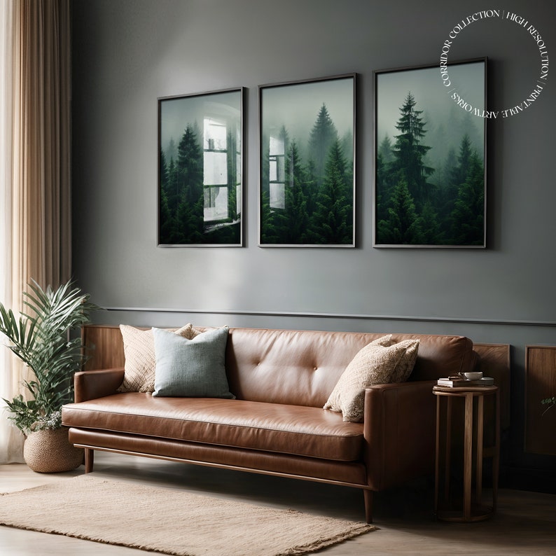 K&ouml;nnte beinhalten: Drei gerahmte Drucke einer nebeligen Waldszene mit hohen immergr&uuml;nen B&auml;umen. Die Drucke h&auml;ngen an einer grauen Wand &uuml;ber einem braunen Ledersofa.