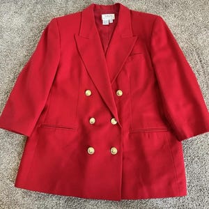 May include: A bright red double-breasted blazer featuring six gold-toned buttons arranged in two vertical rows, wide notched lapels, two front welt pockets, and a single chest pocket. The interior label reads Talbots Petite.