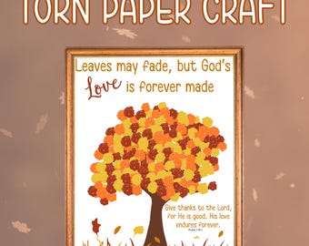 May include: A framed artwork with the text "TORN PAPER CRAFT" at the top. The artwork features a tree with a brown trunk and a colourful crown of orange, yellow, and brown leaves. The text "Leaves may fade, but God's love is forever made" is above the tree.