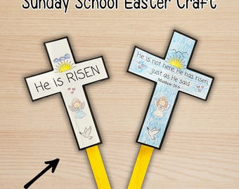 Könnte beinhalten: Zwei handgefertigte Osterbastelkreuze mit den Texten "He is RISEN" und "He is not here, He has risen, just as He said". Jedes Kreuz zeigt eine Zeichnung eines Engels, einer Taube und einer Sonne. Die Kreuze sind an gelben Bastelstäben befestigt.