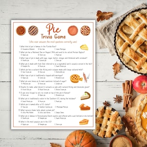 Op de afbeelding: Een pie trivia-spel met verschillende pie-illustraties en een gebakken pie. Het spel bevat vragen over verschillende soorten pies, zoals appel, pompoen en zoete aardappel. De tekst op het spelbord luidt "Pie Trivia Game."