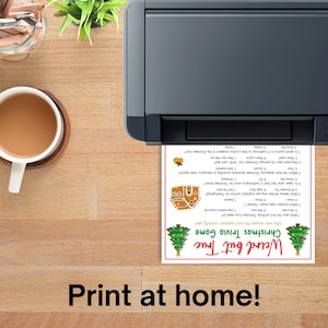 Op de afbeelding: Een printer die een kersttrivia-spelblad afdrukt met een kerstboom en een peperkoekhuisje. De tekst op het blad luidt "Weird but True Christmas Trivia Game". De zin "Print at home!" staat onderaan.