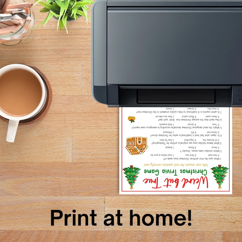 Op de afbeelding: Een printer die een kersttrivia-spelblad afdrukt met een kerstboom en een peperkoekhuisje. De tekst op het blad luidt "Weird but True Christmas Trivia Game". De zin "Print at home!" staat onderaan.