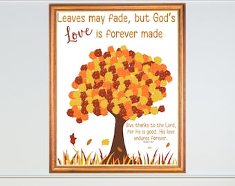 May include: A framed art print with a tree design in autumnal colours. The print includes the text "Leaves may fade, but God's Love is forever made" and a Bible verse. The frame is a warm brown colour.
