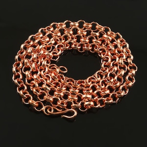 Puede incluir: Un collar de cadena de cobre con cierre de mosquetón. La cadena está hecha de pequeños eslabones redondos.