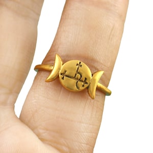 Puede incluir: Anillo de oro con un diseño de triple luna y un sello en el centro.