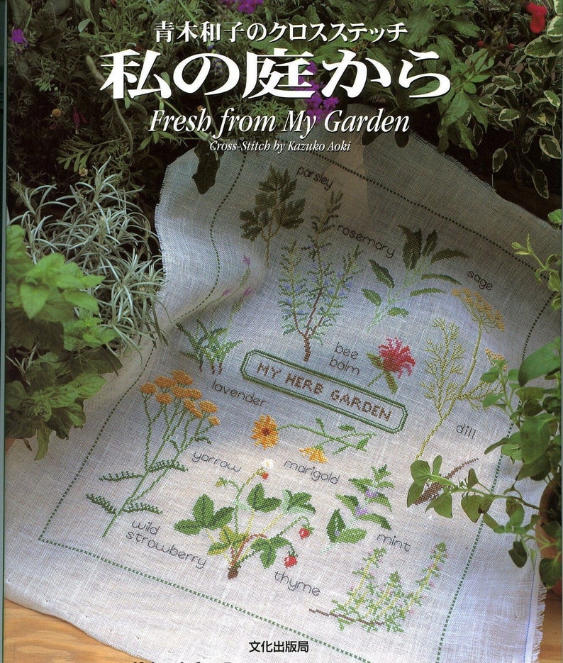 May include: A cross-stitch pattern featuring a variety of herbs and flowers, including parsley, rosemary, sage, bee balm, lavender, yarrow, marigold, wild strawberry, mint, and thyme. The pattern is titled "My Herb Garden" and is surrounded by a green border.