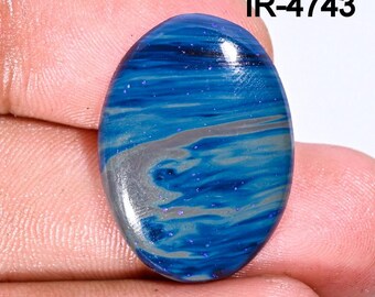 May include: Oval shaped blue and silver gemstone with a swirling pattern and glitter. IR-4743