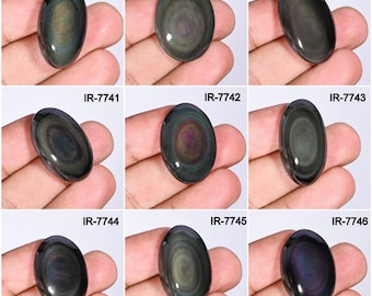 May include: Nine oval-shaped obsidian gemstones with iridescent swirls of color. Each stone is held in a hand and labeled with an "IR" followed by a number. The stones display a range of dark green, black, and purple hues.