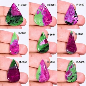 May include: Nine teardrop-shaped green and pink gemstones with black flecks. The gemstones are arranged in three rows of three. Each gemstone is labeled with a unique identification number.