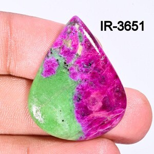 Może przedstawiać: Zielono-różowy kaboszon z kamienia szlachetnego w kształcie łzy. Kamień ma marmurkowy wzór zieleni i różu.