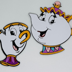 May include: Two cartoon character cutouts: a white teacup with a yellow handle and rim, and a white teapot with a yellow handle and crown. Both have black eyes, pink mouths, and purple and gold accents. The teacup has a purple base.