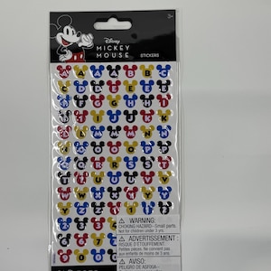 May include: A package of Disney Mickey Mouse stickers. Each sticker features a letter of the alphabet or a number, with the Mickey Mouse head shape incorporated into the design. The letters and numbers are in various colors, including red, yellow, blue, and black.