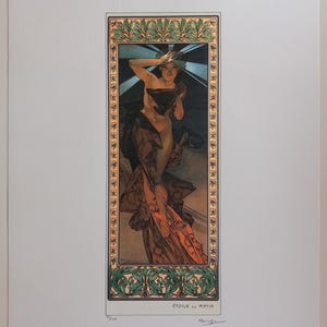May include: Art Nouveau print titled "Étoile du Matin" depicting a woman in flowing robes. The artwork has a decorative border with floral and geometric patterns. The colour palette includes shades of brown, orange, and black.
