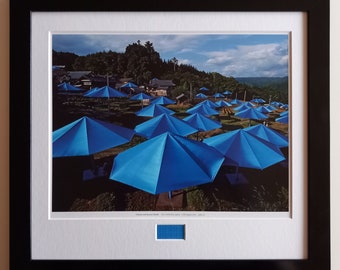 Christo & Jeanne-Claude - Paraplyets Japan – offsetlitografi, inramad med originaltygsbit