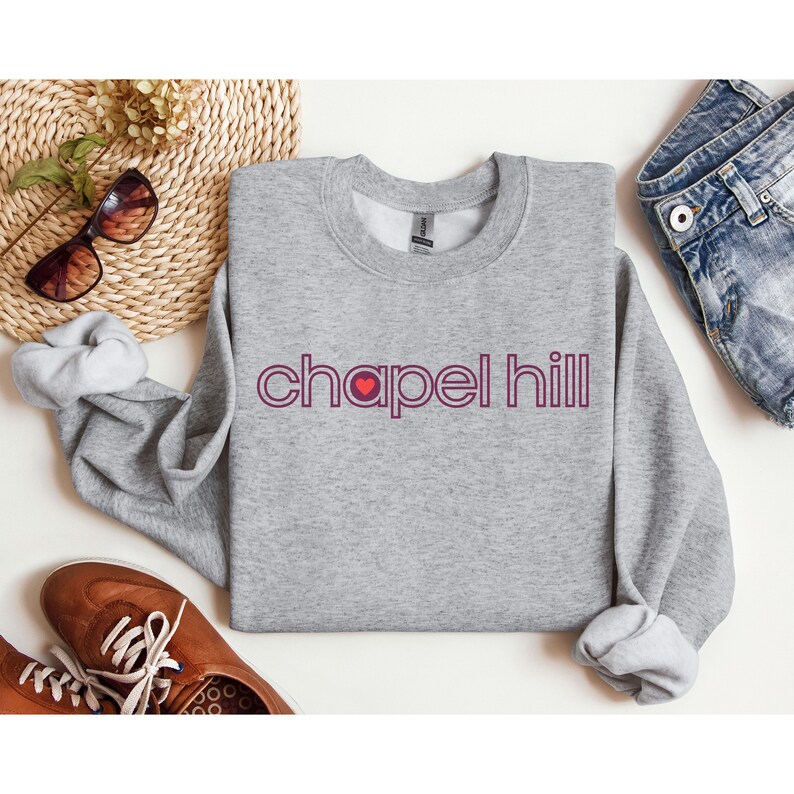May include: A grey sweatshirt with a red heart and the text "chapel hill" in a burgundy colour.