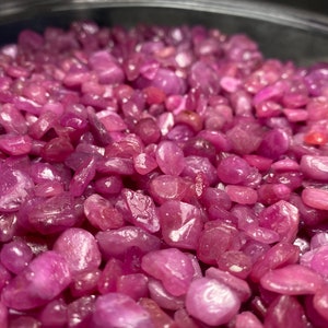 Puede incluir: Primer plano de un cuenco lleno de virutas de rub&iacute; rosa. Las virutas son de varios tama&ntilde;os y formas, con un acabado liso y pulido.