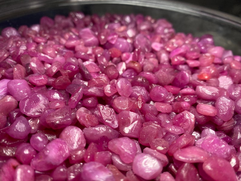 Puede incluir: Primer plano de un cuenco lleno de virutas de rub&iacute; rosa. Las virutas son de varios tama&ntilde;os y formas, con un acabado liso y pulido.