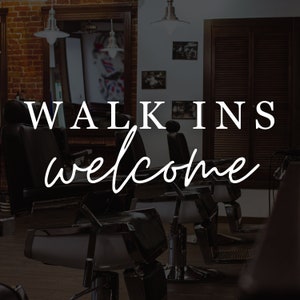 May include: A barbershop interior with multiple black leather barber chairs, a brick wall, and a sign that reads "WALK INS welcome".