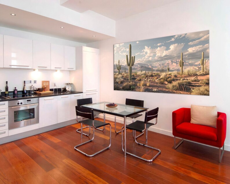 Puede incluir: Un comedor moderno con una cocina blanca y una gran impresi&oacute;n de paisaje des&eacute;rtico colgada en la pared. La mesa de comedor es de vidrio y tiene cuatro sillas negras. Un sill&oacute;n rojo con un coj&iacute;n beige est&aacute; en la esquina de la habitaci&oacute;n.