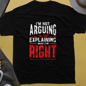 May include: Black t-shirt with white text that reads "I'm not arguing I'm just explaining why I'm RIGHT" in red.