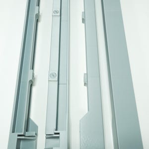 May include: Four light gray, plastic components, possibly for a larger structure, are arranged vertically against a white background. The pieces have a channel or track design, with varying lengths and shapes, suggesting a modular or assembly-based product.