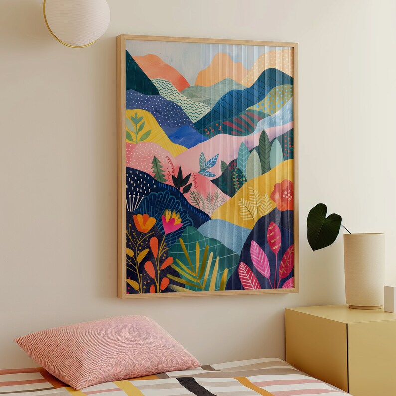 May include: A framed art print showcasing a vibrant, abstract landscape. The artwork presents rolling hills and stylized flora in shades of pink, blue, yellow, and green. The print is enclosed in a light brown wooden frame, enhancing the colourful design.