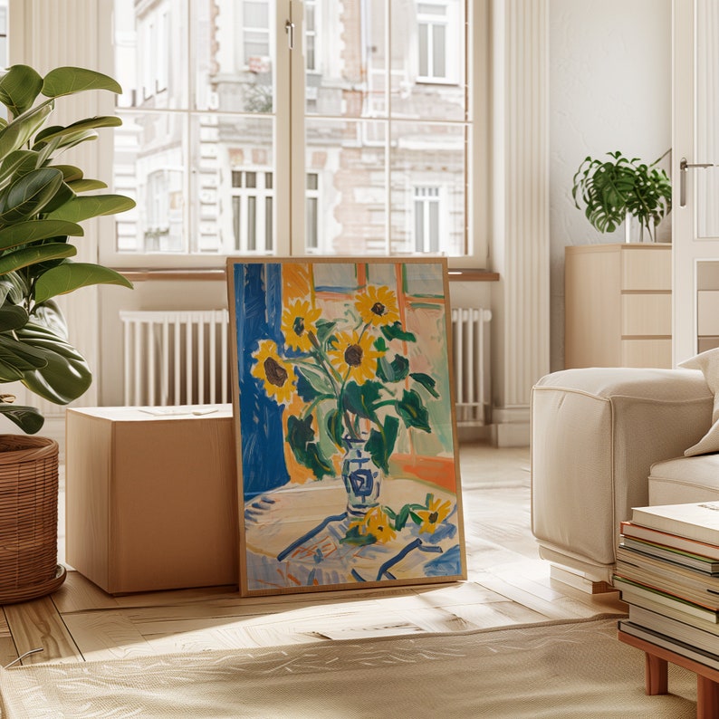 May include: A framed painting of a still life with a vase of yellow sunflowers on a white tablecloth. The vase is blue and white with a floral pattern. The background is a blue and orange abstract design.
